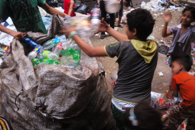 Coptic Christians in Cairo's El Zabaleen (garbage city) slum sift through piles of trash.