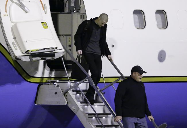 Matthew Miller, top, walks off the plane after arriving back in the United States.