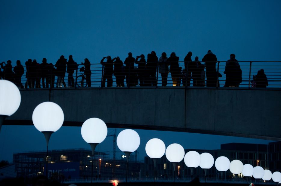 People look at balloons of the art project Lichtgrenze (Border of Light) in Berlin. 