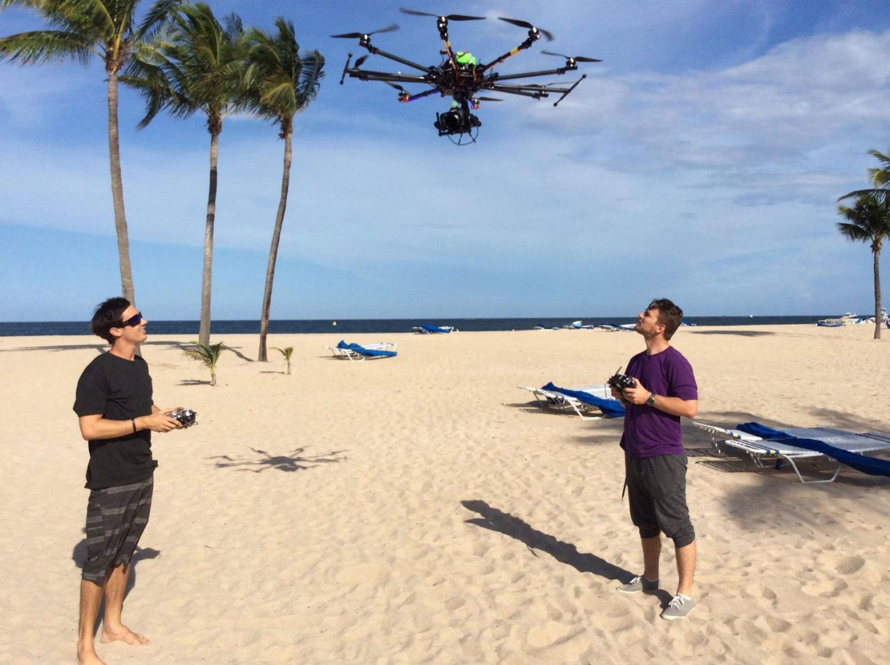 Justice L Bentz (left) and a fellow operator get one of their custom-built drones off the ground, ready to shoot another superyacht in the Caribbean.