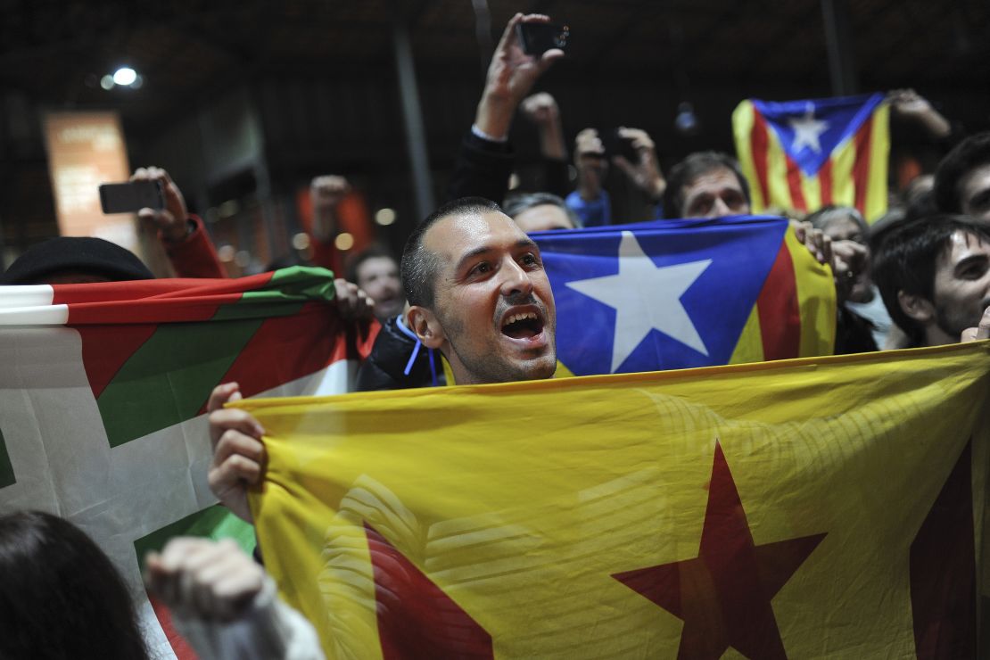 Pro-independence supporters hold Basque and Catalan independence flags.