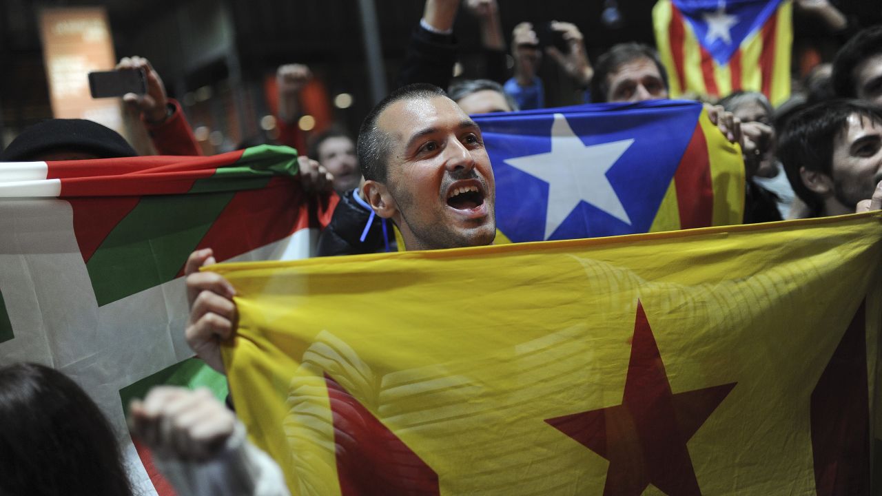 Pro-independence supporters hold Basque and Catalan independence flags.