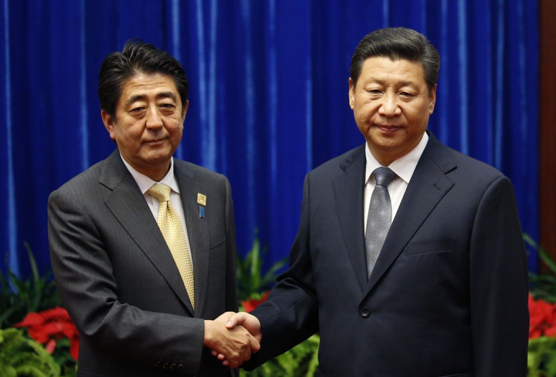 China's President Xi Jinping (R) shakes hands with Japan's Prime Minister Shinzo Abe in Beijing, 2014.