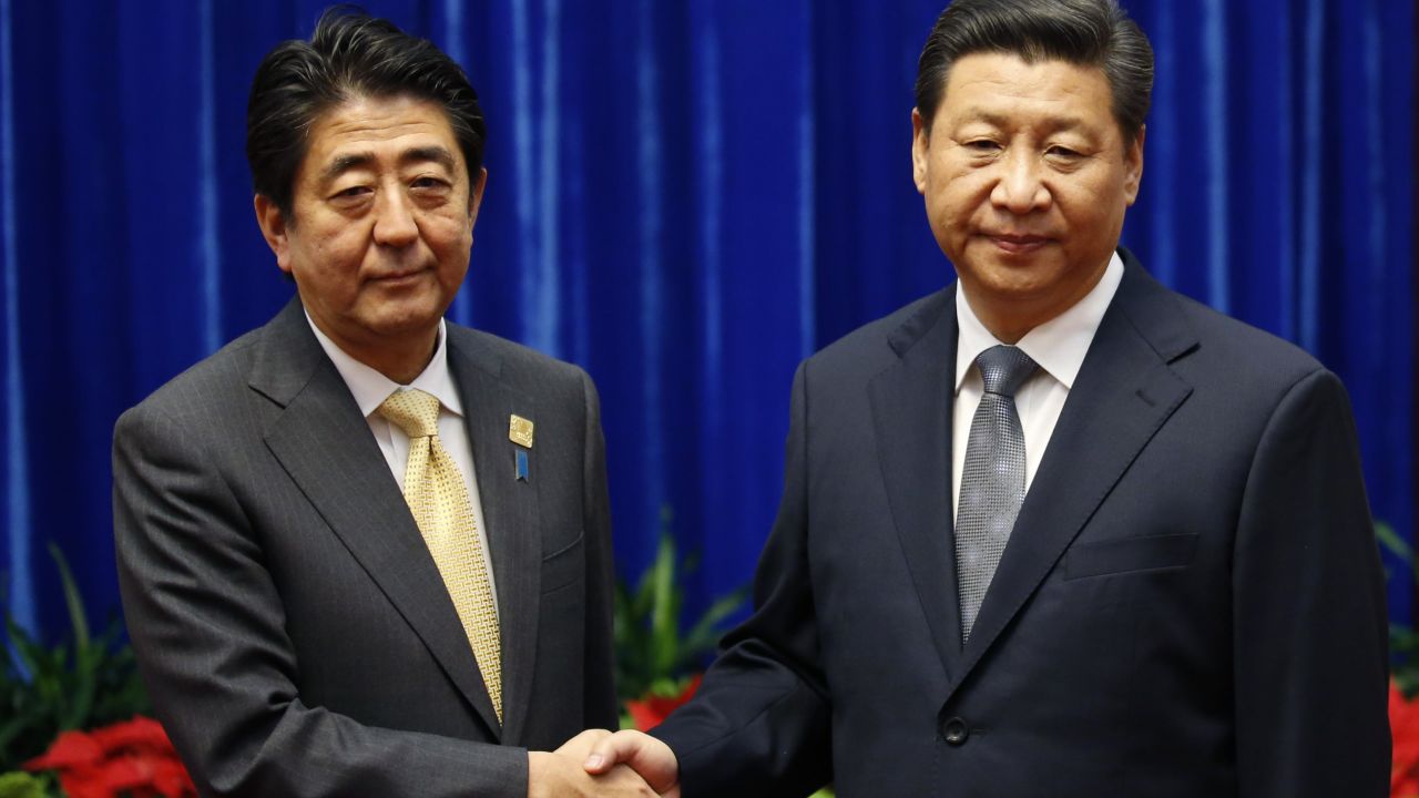China's President Xi Jinping (R) shakes hands with Japan's Prime Minister Shinzo Abe, during their meeting on the sidelines of the Asia Pacific Economic Cooperation (APEC) meetings on November 10 in Beijing, China.