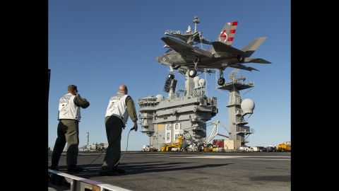 An F-35C passes over the deck of the USS Nimitz during testing.