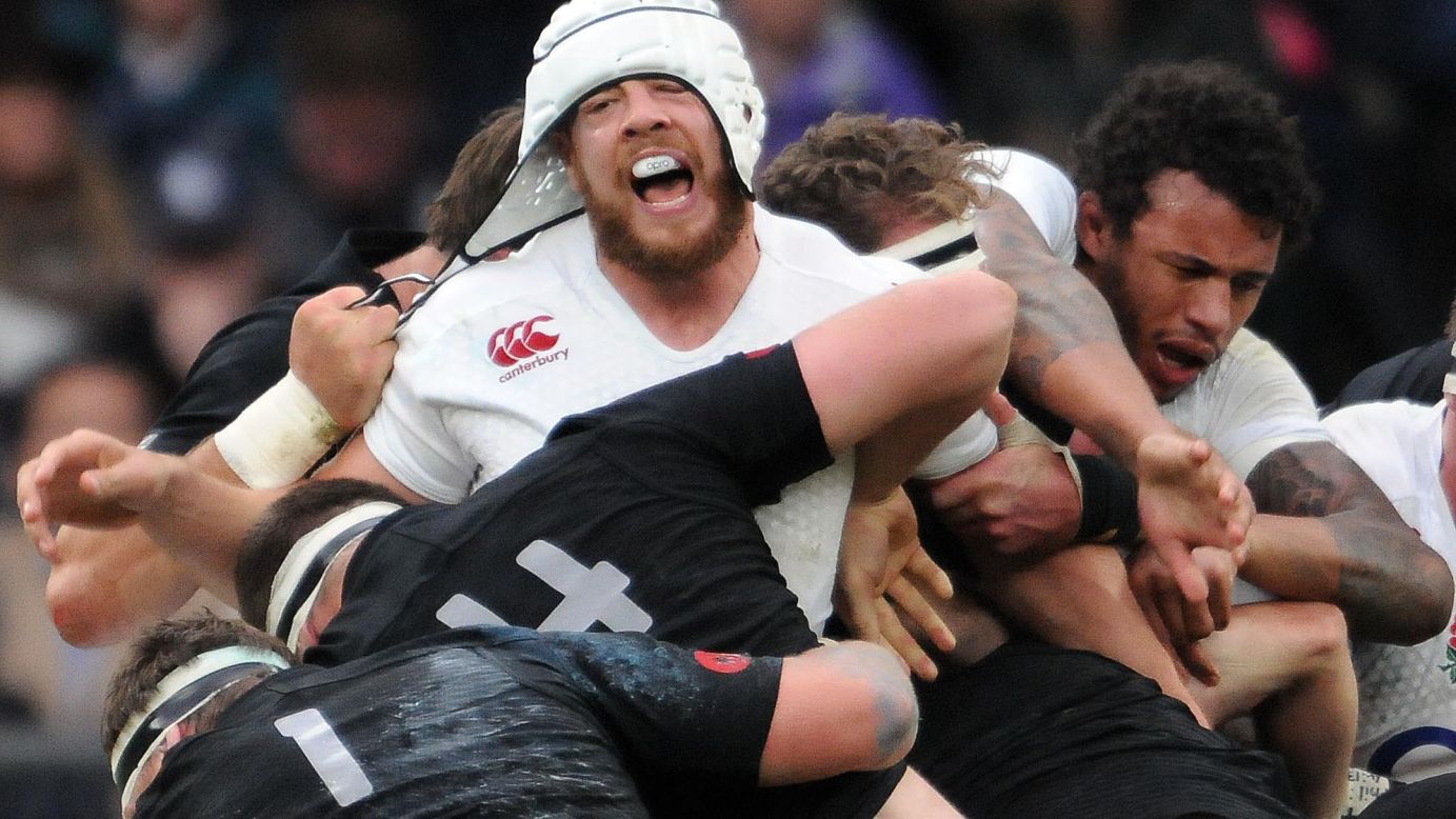 Dave Attwood of England gets his protective head gear pulled by Samuel Whitelock of New Zealand during the QBE autumn international rugby match in London on Saturday, November 8. New Zealand won 24-21.