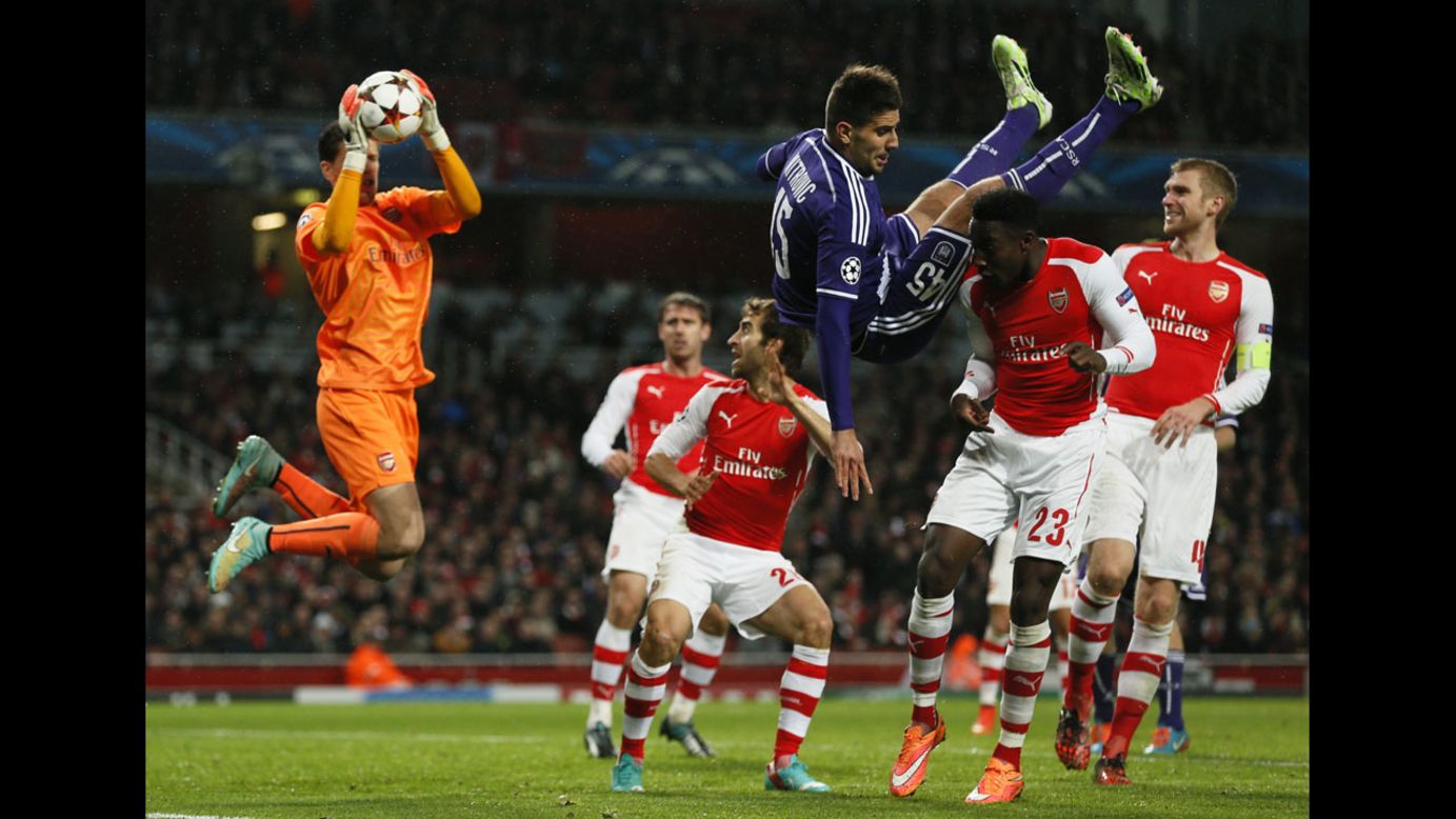 Arsenal's Danny Welbeck, second from right, challenges Anderlecht's Cyriac as Arsenal's goalkeeper Wojciech Szczesny catches the ball during their Champions League match at the Emirates stadium in London on Tuesday, November 4. The game ended 3-3.