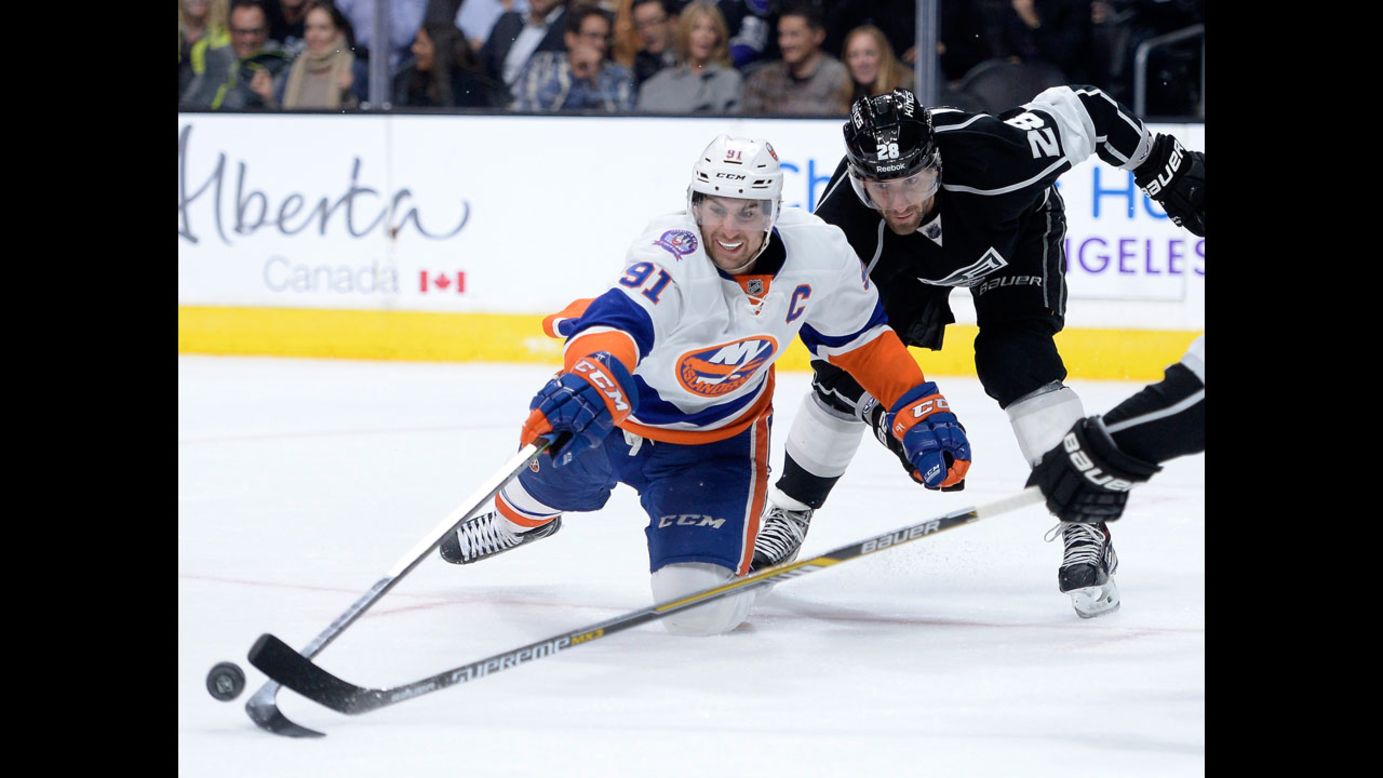 John Tavares of the New York Islanders reaches for the puck with Jarret Stoll of the Los Angeles Kings during the third period at Staples Center in Los Angeles on Thursday, November 6. The Islanders won 2-1.