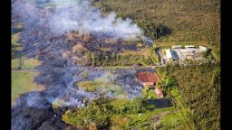 This Monday, Nov. 10, 2014 photo released by The County of Hawaii via Ena Media Hawai'i/Blue Hawaiian Helicopters shows lava flow from the Kilauea Volcano near a residential structure in Pahoa, Hawaii. A stream of lava set a home on fire Monday in a rural Hawaii town that has been watching the slow-moving flow approach for months. (AP Photo/The County of Hawaii)