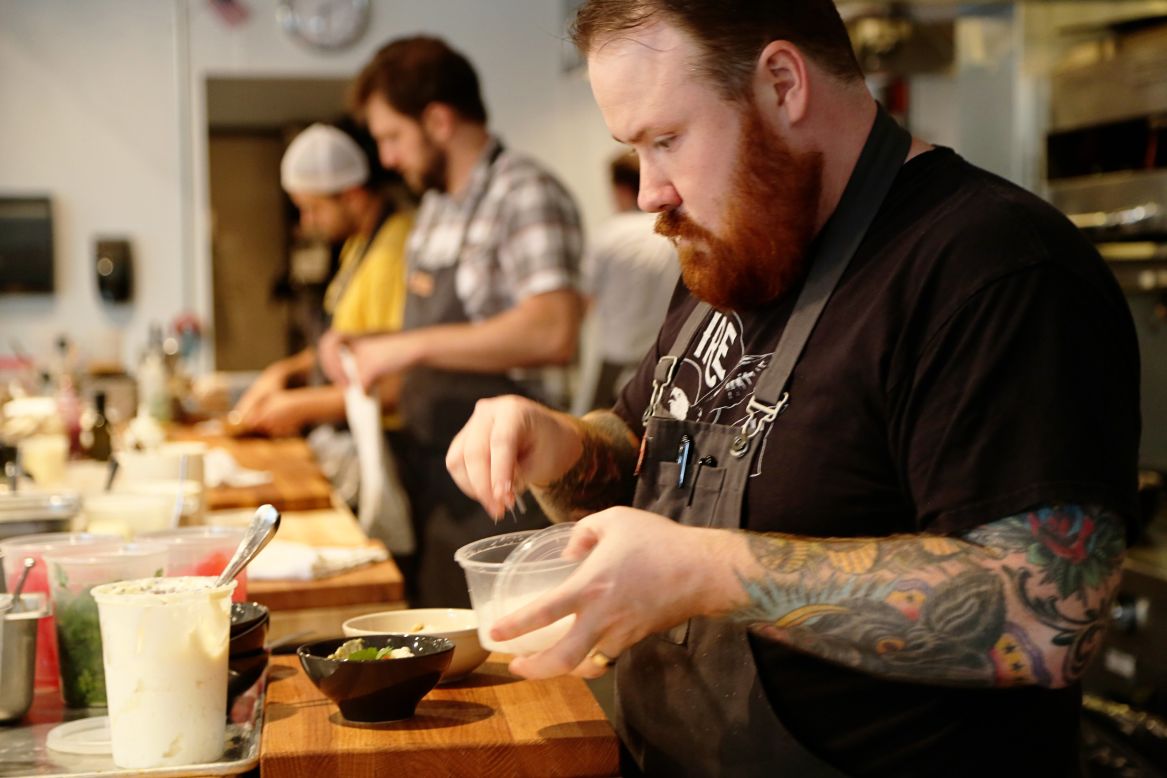 Atlanta native and former "Top Chef" contestant Kevin Gillespie works in the open kitchen at his latest restaurant, Gunshow. Sampling Atlanta's many enticing eateries is a must for visitors.