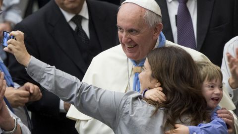 Pope Francis poses for a selfie with a mother and her child Saturday, November 8, in Vatican City.