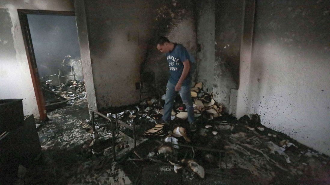 A man walks through rubble after demonstrators set the Institutional Revolutionary Party's headquarters ablaze in Chilpancingo, Guerrero state, Mexico, on November 11. 
