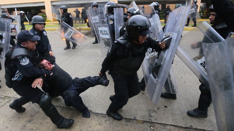 A wounded riot police officer is rescued from violent demonstrators on November 10. 