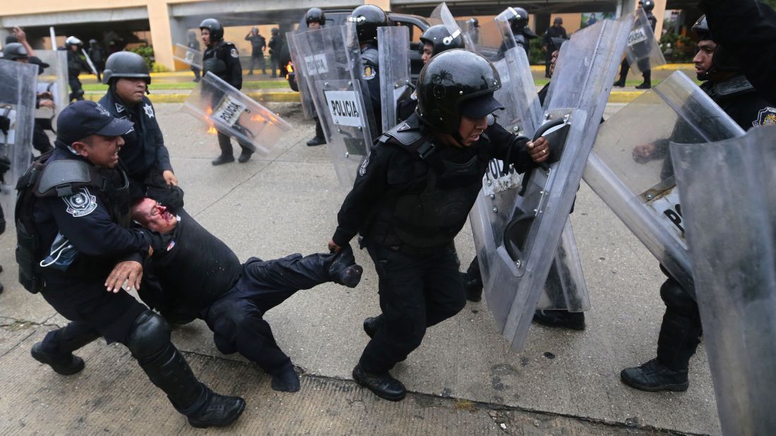 A wounded riot police officer is rescued from violent demonstrators on November 10. 
