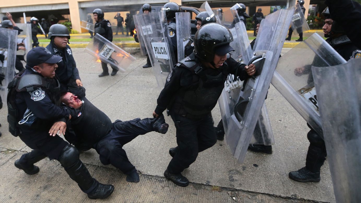 Un oficial de la policía anti disturbios herido es rescatado de entre los violentos manifestantes el 10 de noviembre.