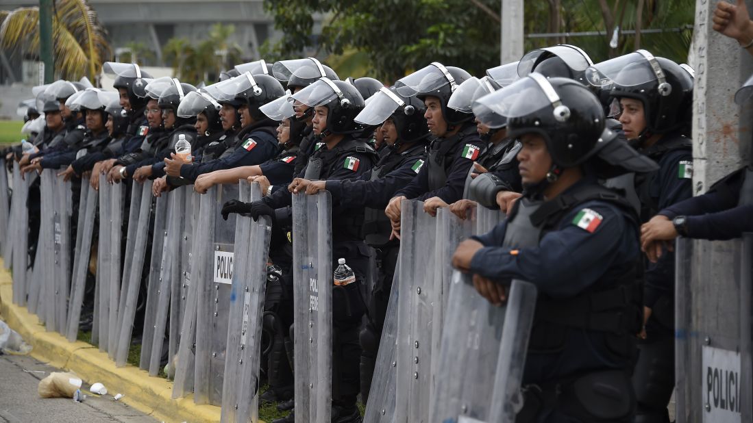 Riot police stand guard near the airport in Acapulco on November 10. 