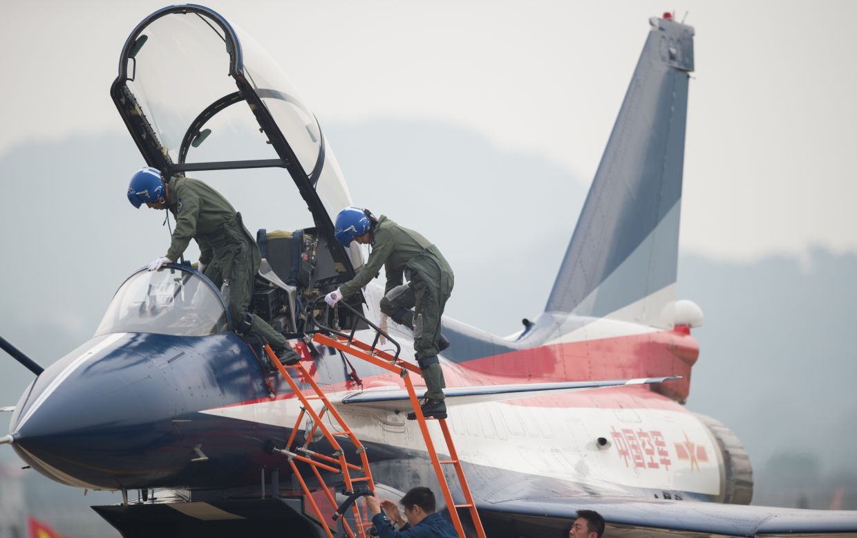 Pilots climb into a J-10 fighter jet on Tuesday, November 11, 2014. 