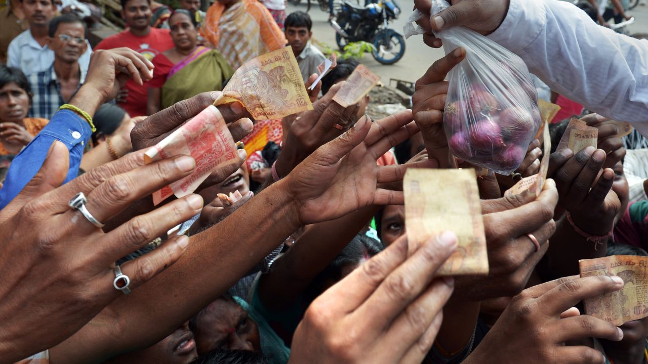 low-income Indians scramble to buy onions at a price of 10 rupees (0.16 USD) for 500 grams, subsidised by a local club, in Kolkata on October 29, 2013. The price of onions, a staple in Indian cooking, have gone through the roof in the past few months, quadrupling to as much as 100 rupees a kilogram ($1.65) in parts of the country and turning the vegetable into an unaffordable luxury for the poor. AFP PHOTO/Dibyangshu SARKAR (Photo credit should read DIBYANGSHU SARKAR/AFP/Getty Images)