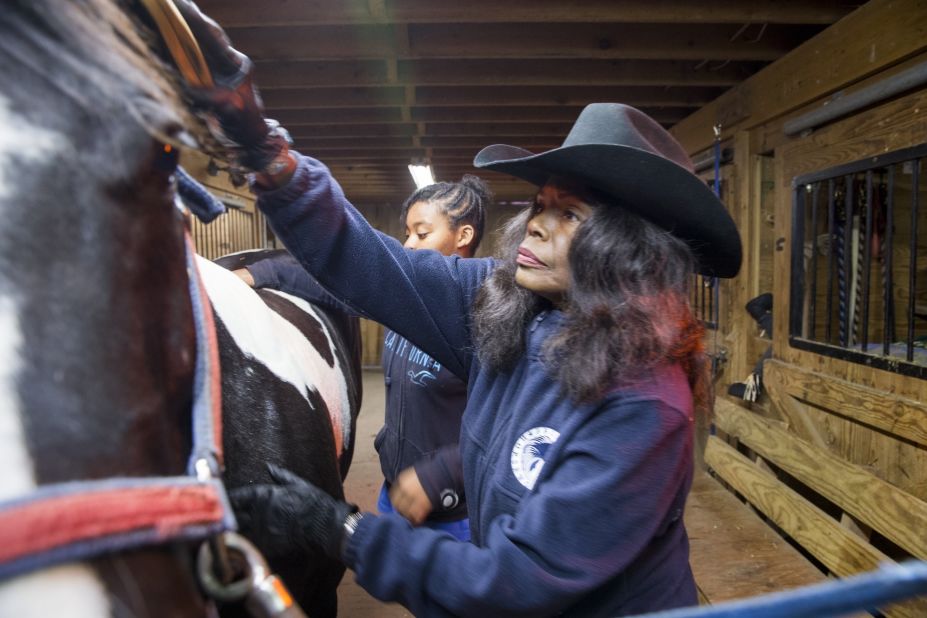 Patricia Kelly grooms a horse on her farm in Hartford, Connecticut. Kelly's nonprofit, Ebony Horsewomen, teaches horseback riding and animal science to at-risk youths, offering them an alternative to the streets.