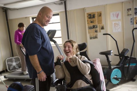 Ned Norton works with a woman at his gym in Albany, New York. For the past 25 years, Norton has provided free and low-cost strength training for people living with disabilities.
