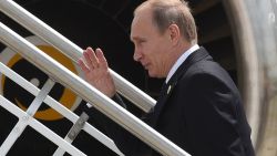 This handout photo taken and released by G20 Australia on November 16, 2014 shows Russias President Vladimir Putin (C) waving goodbye as he leaves the G20 Summit, at the airport in Brisbane. Putin jetted out of Australia after a testy G20 summit where he faced concerted Western fire over the Ukraine crisis, saying he left slightly early because he needed to get some sleep. AFP PHOTO / Steve Holland/ G20 Australia 