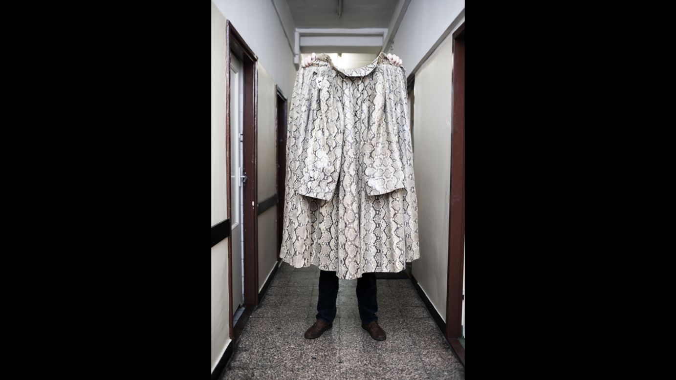 A snake skin coat is held up in Warsaw. "This project aims to show human arrogance and folly and to build in us humility," Lach said.