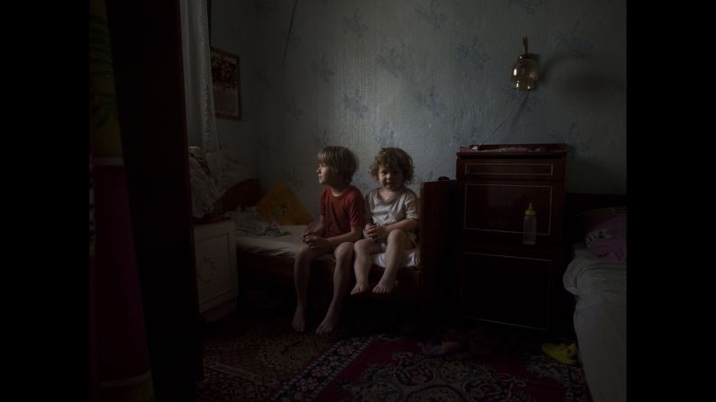 Nadia and Olga Jershova sit on their bed in Slovyansk after mortars and machine gun fire hit their window.