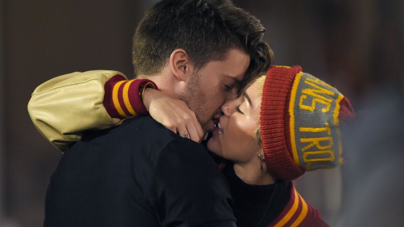 Pop star Miley Cyrus, right, kisses Patrick Schwarzenegger, son of actor Arnold Schwarzenegger, while attending the college football game between California and USC on Thursday, November 13.