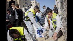Response teams clean blood from the streets near the synagogue.