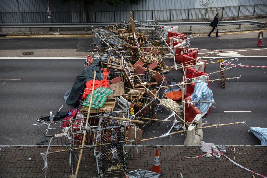 A businessman walks to work past protester-placed barricades that blocked a road at the Admiralty protest site on Thursday, November 13.