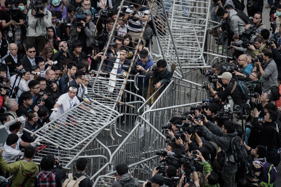 Security staff members remove a barricade outside the CITIC tower near a protest site in the Admiralty district of Hong Kong on Tuesday, November 18. 