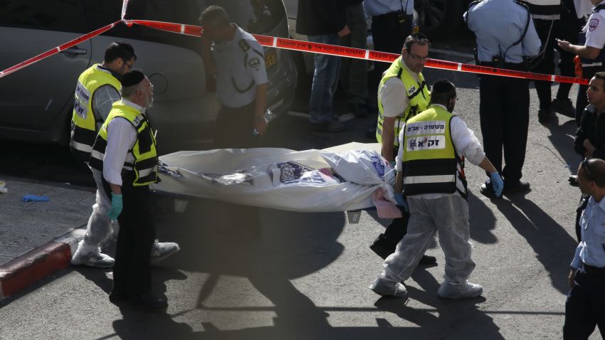 Israeli Zaka emergency services volunteers carry the body of one of the two Palestinian assailants who were shot dead while attacking a synagogue in the ultra-Orthodox Har Nof neighbourhood in Jerusalem on November 18, 2014. The attack, that killed four Israelis, began shortly before 7am (0500 GMT) as worshippers were attending morning prayers. AFP PHOTO / GALI TIBBON        (Photo credit should read GALI TIBBON/AFP/Getty Images)