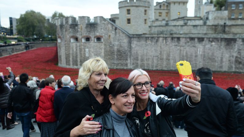 Visitors pose for a selfie on Tuesday, November 11, the last day of the Tower of London's <a href="http://www.cnn.com/2014/08/04/europe/gallery/tower-of-london-art-installation/index.html">ceramic poppy installation.</a> Thousands of ceramic poppy flowers have been installed in the dry moat surrounding the tower to mark the 100th anniversary of World War I. There are 888,246 ceramic poppies, one for each British military member that died during the war. The installation, called "Blood Swept Lands and Seas of Red," was created by artist Paul Cummins.