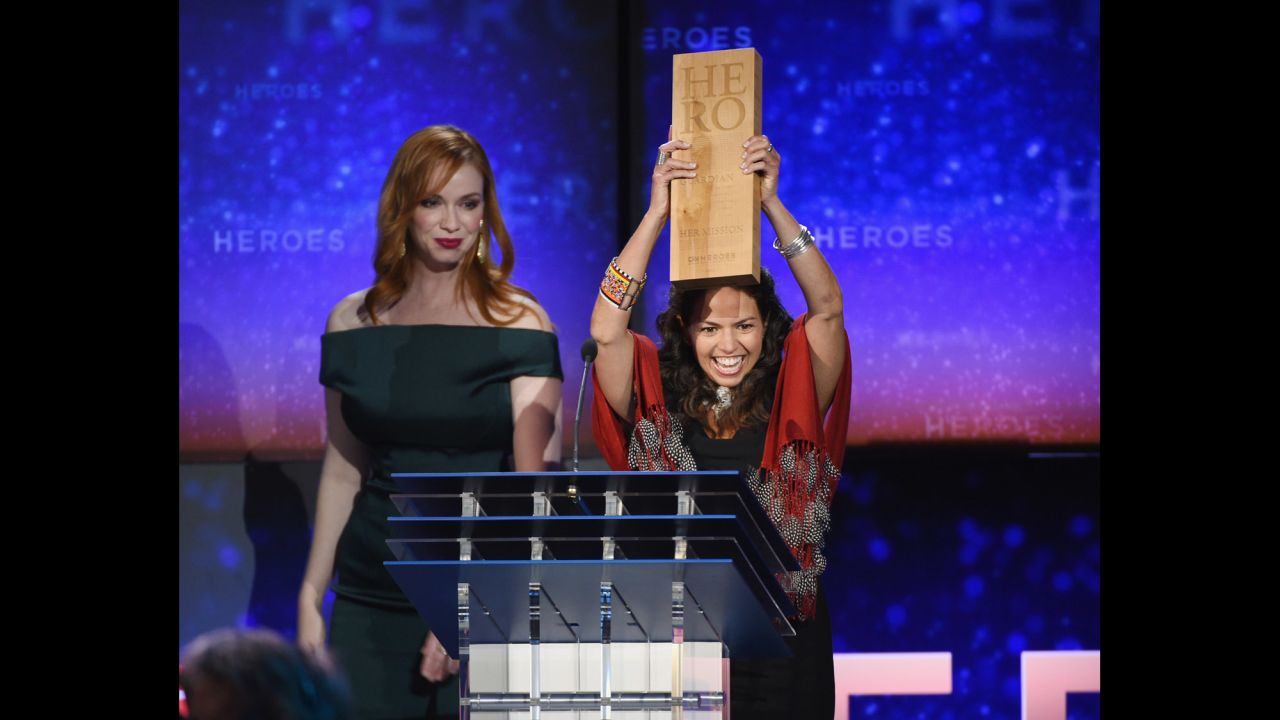 CNN Hero Leela Hazzah, who is <a href="http://www.cnn.com/2014/11/24/world/gallery/cnn-heroes-leela-hazzah/index.html">helping to save lions</a> in Africa, holds up her award next to actress Christina Hendricks during the show.
