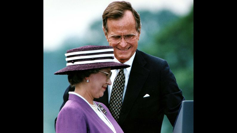 President George Bush steps aside for Queen Elizabeth II to address the crowd attending a welcoming ceremony at the White House in Washington, DC, on May 14, 1991.