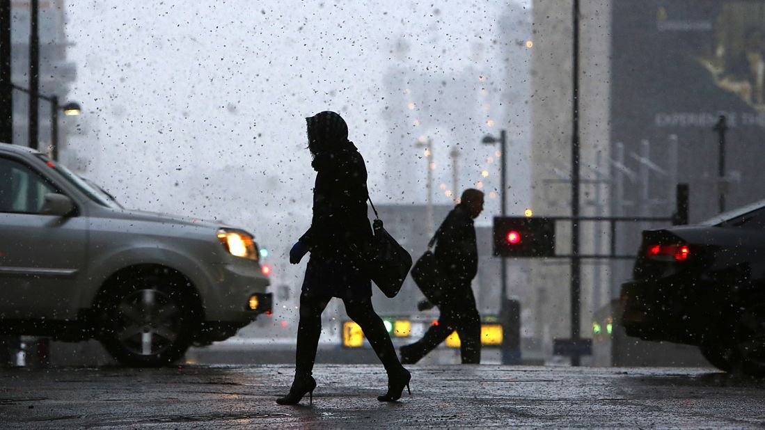 Pedestrians make their way through downtown Cincinnati during the season's first snowfall on November 17.