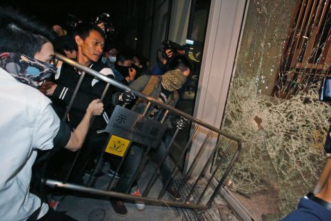 Protesters break a glass door of the Legislative Council on Wednesday, November 19. 
