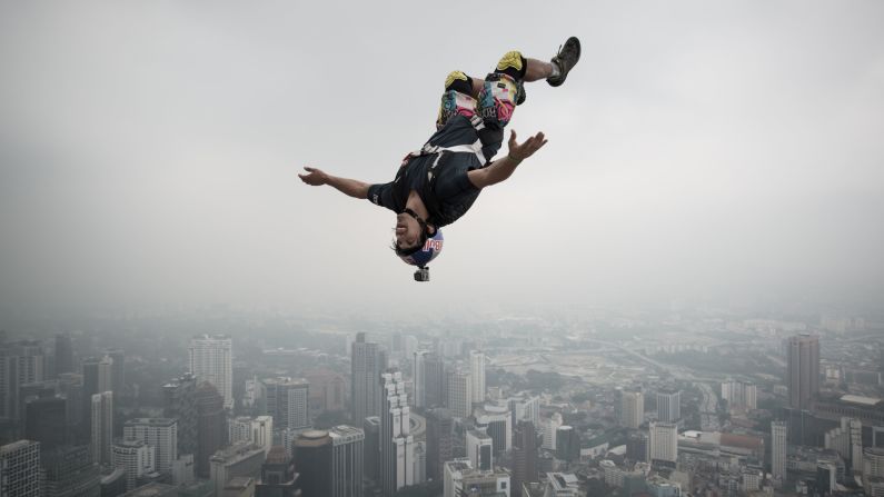 Un saltador base se lanza desde una terraza abierta de 298,7 metros de la Torre Kuala Lumpur, en Malasia. El salto base es un deporte extremo en el que sus participantes saltan desde estructuras fijas y utilizan un paracaídas para disminuir la velocidad del descenso.
