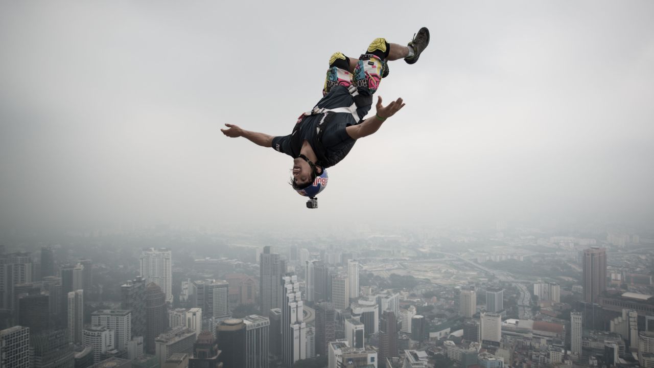 A base jumper leaps from the 980-foot open deck of Malaysia's Kuala Lumpur Tower. <a href="http://www.cnn.com/interactive/2014/11/specials/wish-you-were-here/index.html#basejump">Base jumping</a> is an extreme sport in which participants leap from fixed objects and use parachutes to slow their falls.