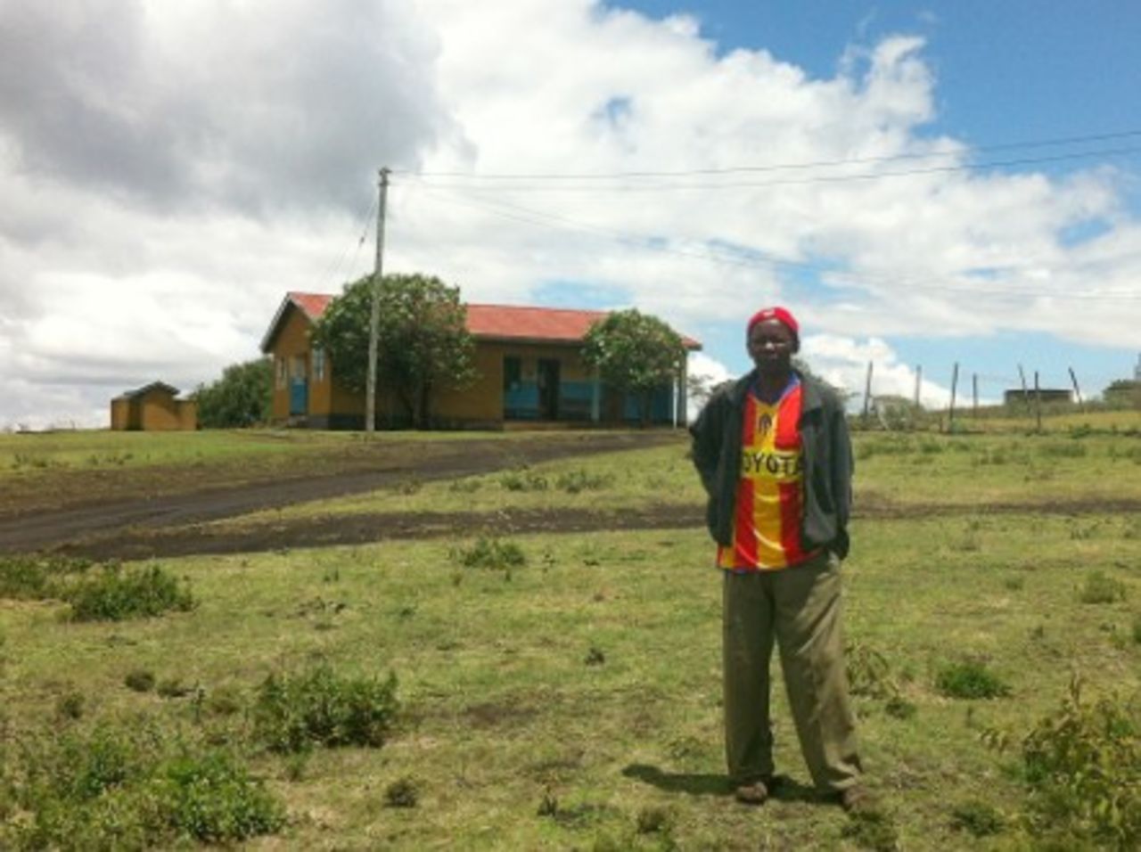 Maasai community member Jacob Mmali standing by his local health dispensary.