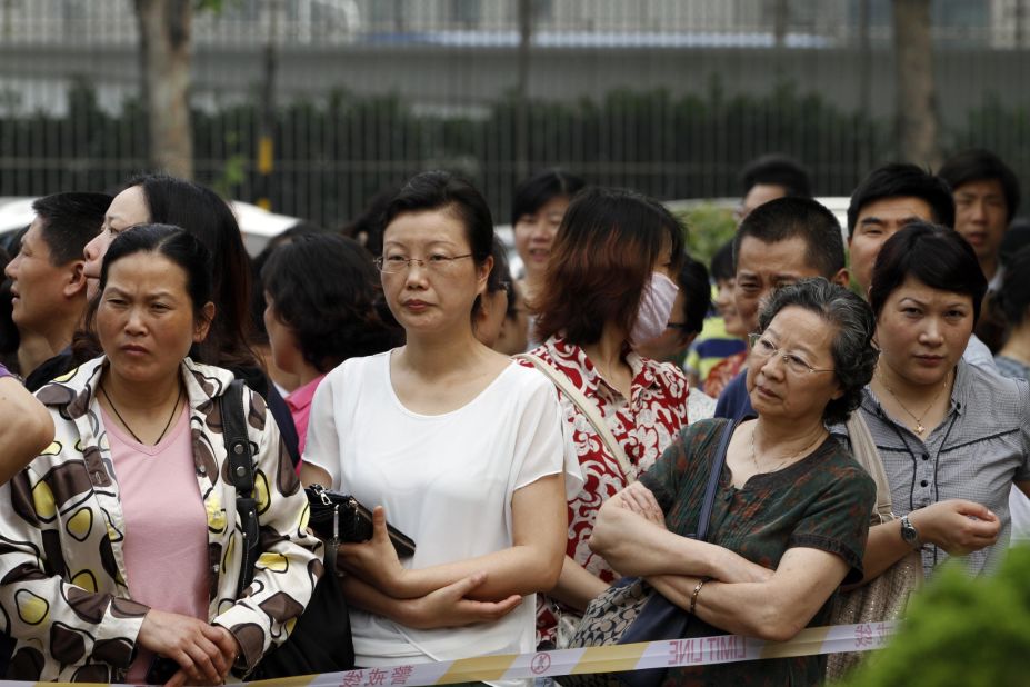 Family members wait outside a school as students sit the 2014 college entrance exam of China, or the "gaokao," in Nanjing, east China's Jiangsu province. Parents of China's increasingly moneyed middle class are opting for private education they feel will give their children the edge in gaining places at foreign universities.