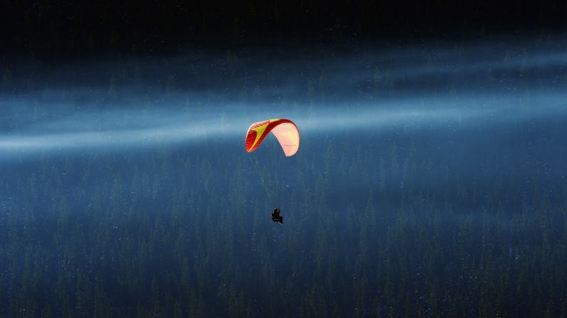 A paraglider flies over the Oster-Jansjon lake in Are, Sweden. In the right conditions, paragliding flights can last for hours and reach thousands of feet in altitude.