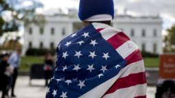 Jose Cruz wears a U.S. flag during a demonstration in favor of immigration reform outside of the White House in Washington, D.C., U.S., on Friday, Nov. 7, 2014.
