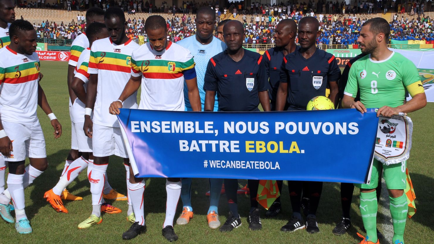 Mali's team captain Seydou Keita (C), Algeria's captain Medhi Lacen (R) hold a banner reading ''Together we can fight Ebola'' during 2015 Africa Cup of Nations qualifying.