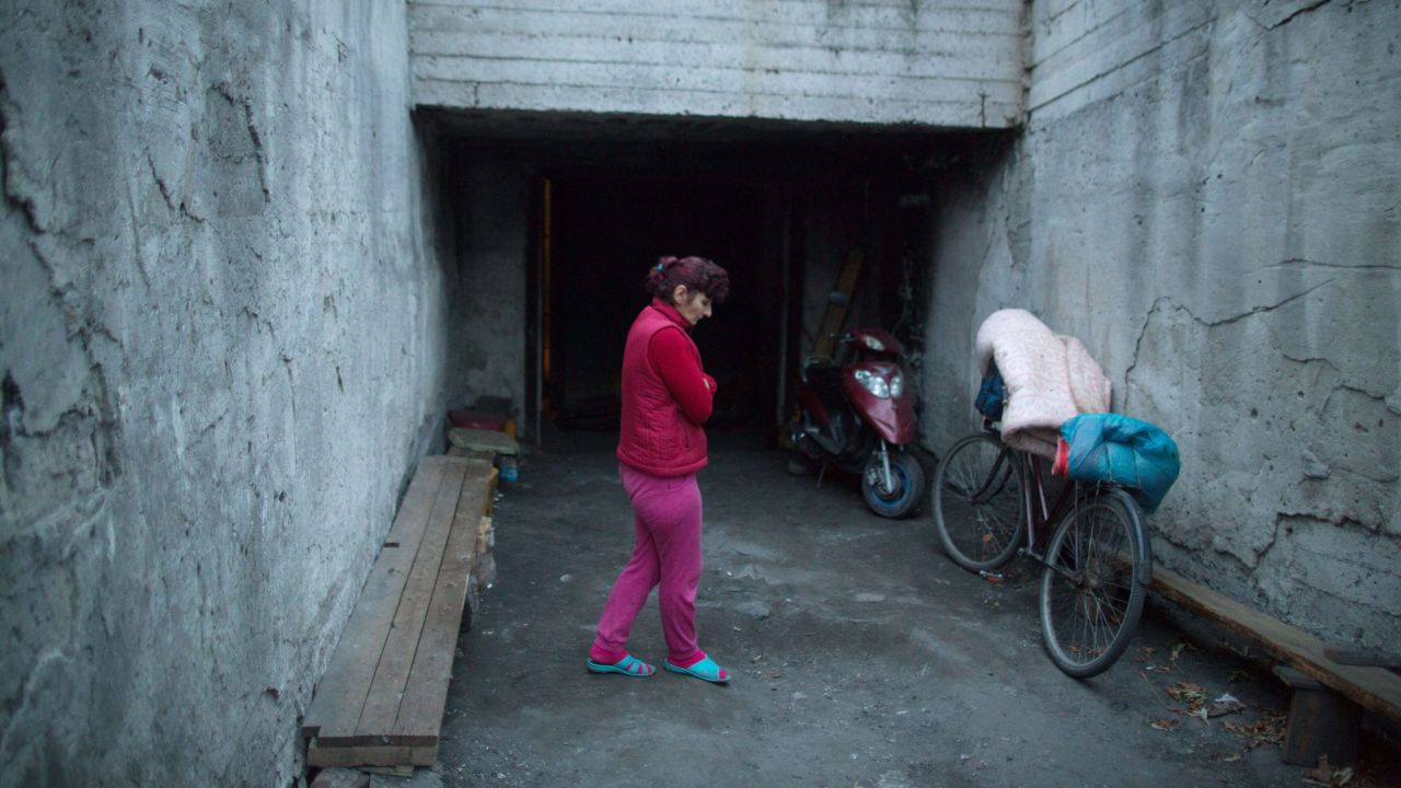 A woman, resident of the Prtrovskiy neighborhood of Donetsk, eastern Ukraine stands outside a shelter on November 17.