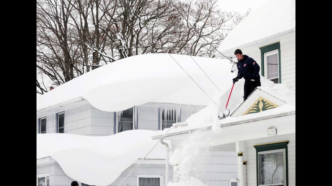 Andrew Zelak cleans snow from his roof in Alden, New York, on November 20.