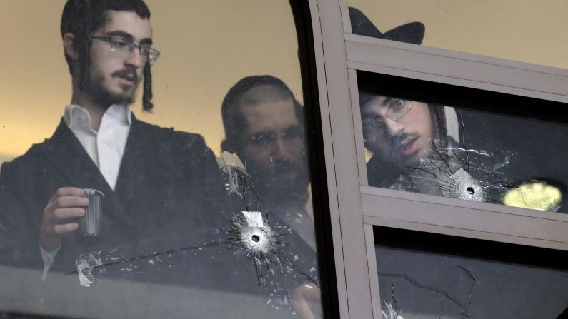 Men look at bullet holes on the main window of a Jerusalem synagogue that was attacked Tuesday, November 18, by two Palestinian men. Four worshippers and a police officer were killed and several others were wounded in the <a href="http://www.cnn.com/2014/11/18/middleeast/gallery/jerusalem-synagogue-attack/index.html">deadliest terror attack in Jerusalem</a> since 2008.