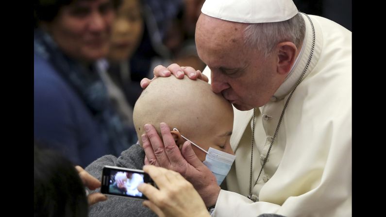 Pope Francis kisses a girl Friday, November 14, during a special audience with business consultants at the Vatican.