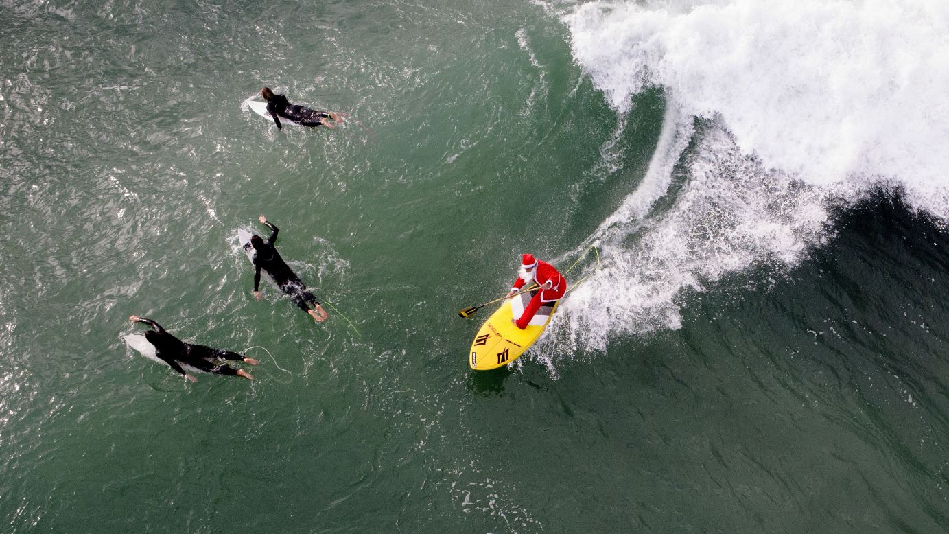 A man dressed as Santa Claus rides a wave in Varazze, Italy, on Tuesday, November 18.