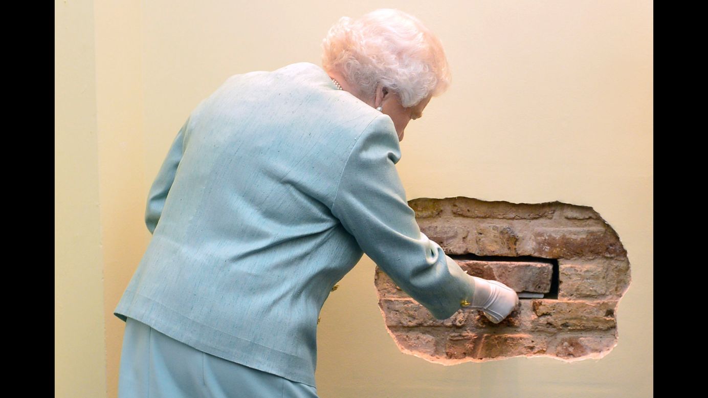 Britain's Queen Elizabeth II removes a brick Tuesday, November 18, during a ceremony in London for the launch of the Queen Elizabeth II Academy for Leadership in International Affairs.
